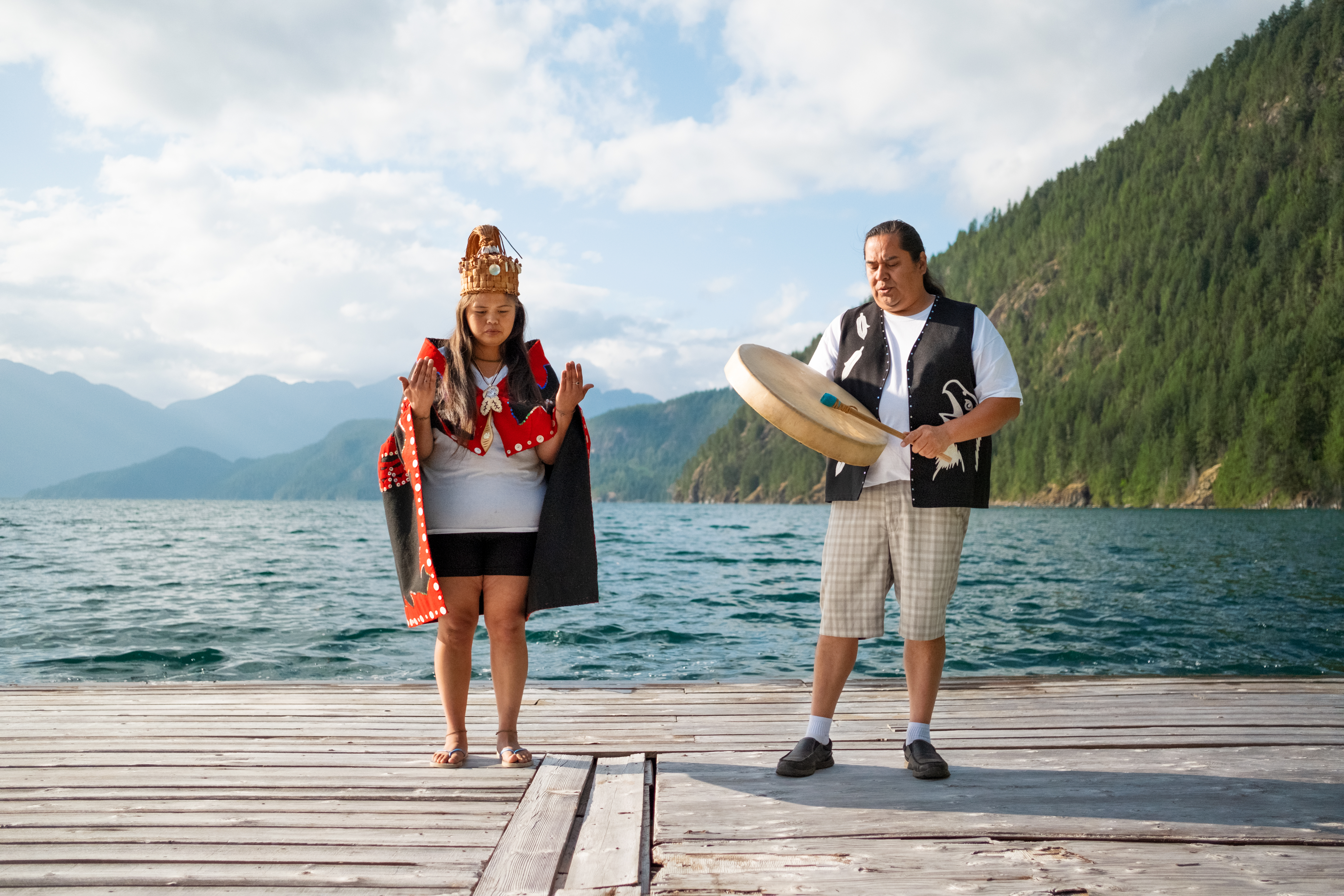 Indigenous woman and man in front of lake